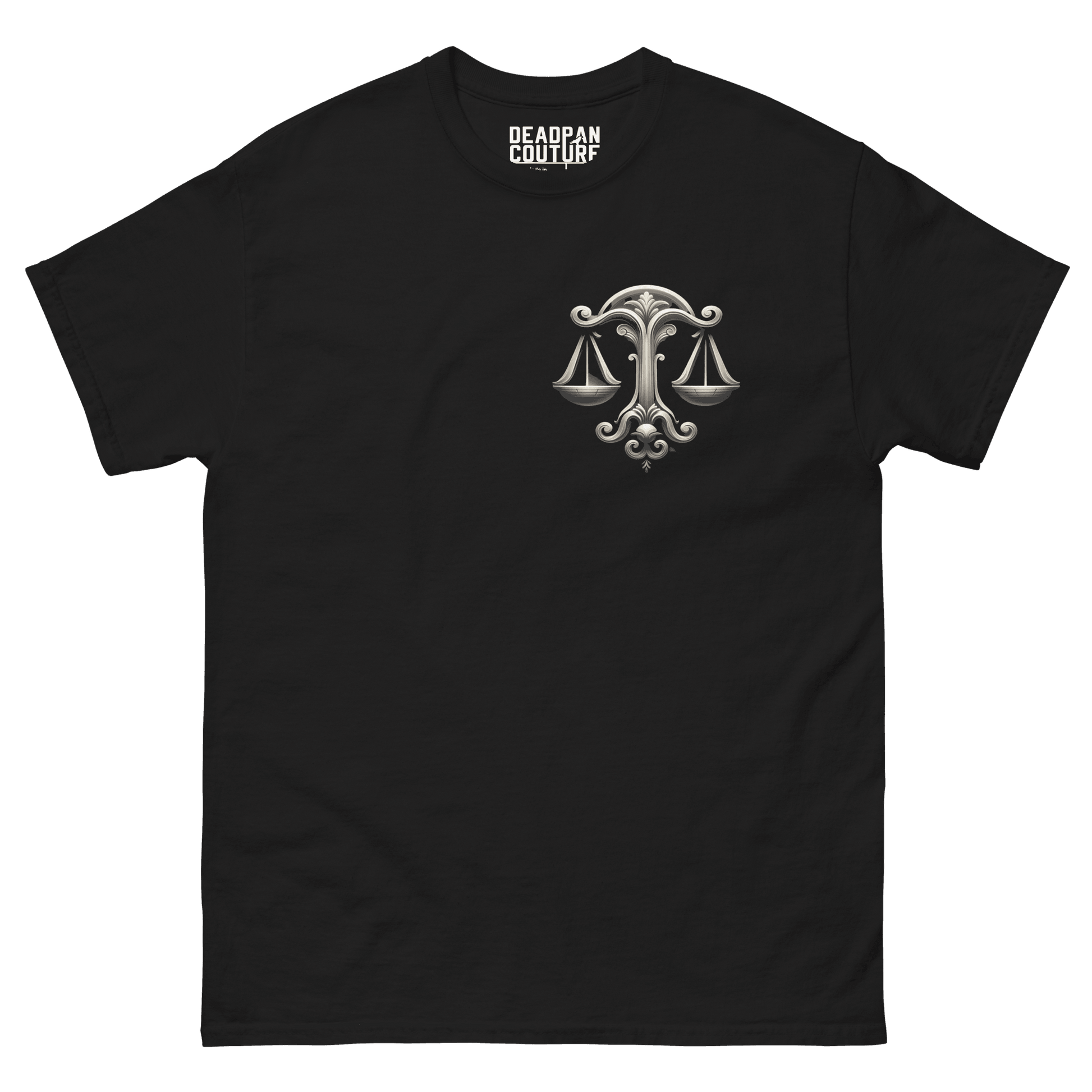 A black Deadpan Couture t-shirt featuring a detailed design on the left chest area. The graphic displays an ornate set of scales, symbolizing the Libra zodiac sign. The intricate, monochrome design contrasts with the black fabric, creating a subtle yet impactful visual element on the t-shirt.