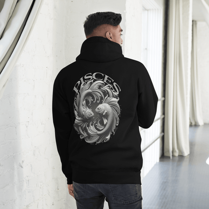  A man is standing in a stylish indoor space, seen from the back while wearing a black Deadpan Couture hoodie. The back of the hoodie features a large, detailed design of two stylized fish swimming in a circular motion, symbolizing the Pisces zodiac sign. The word "PISCES" is prominently displayed above the graphic, creating a striking contrast against the black fabric.