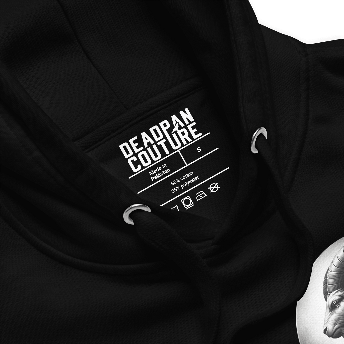 Close-up of Deadpan Couture Unisex Premium Hoodie featuring a minimalist Capricorn emblem on the front, showcasing product details and fabric blend.