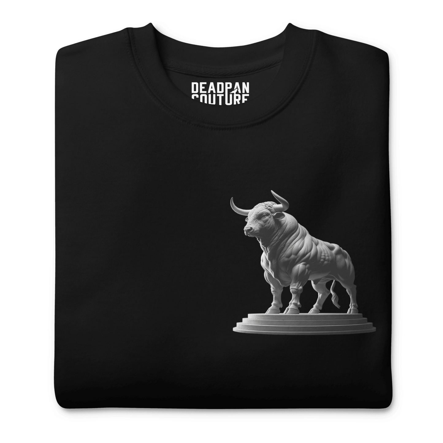 A neatly folded black Deadpan Couture sweatshirt with the Taurus bull statue design visible on the front left chest area. The illustration is clean and prominent against the black fabric.