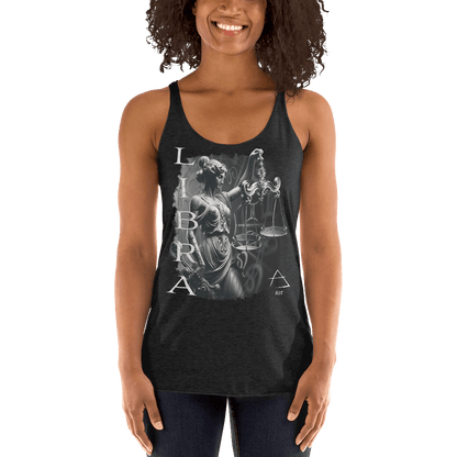 The same woman is shown from the front, smiling, while wearing the black racerback tank top. The front features a large, detailed design of the Libra zodiac sign. The graphic includes a stylized depiction of Lady Justice holding scales, with the word "LIBRA" vertically aligned beside the image. The design is intricately detailed, standing out against the dark fabric.